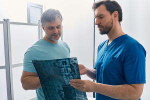 Doctor Showing Mri Image Of Spine To Patient During Medical Cons